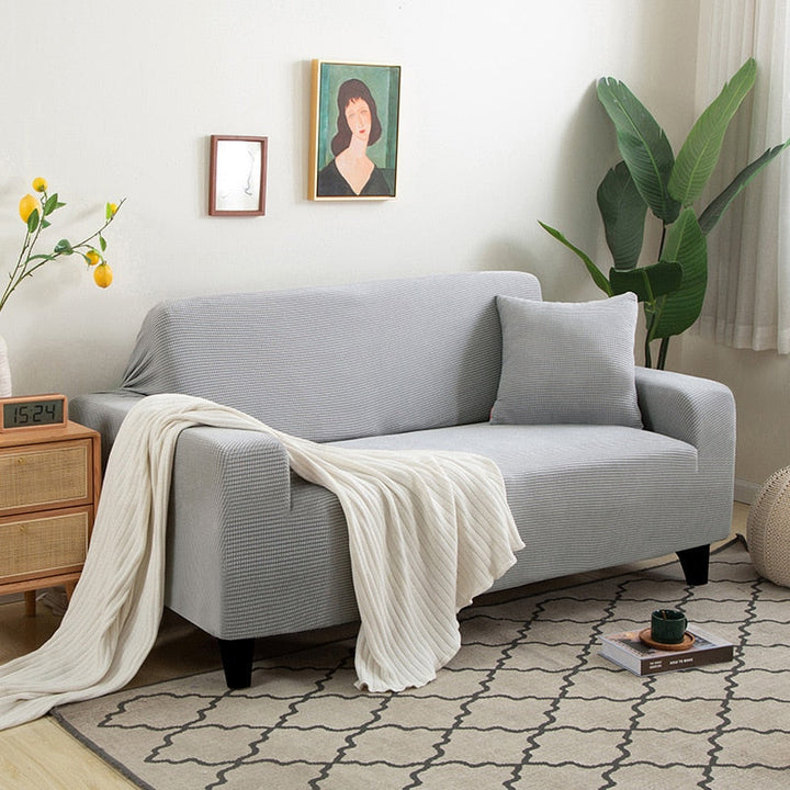 "Textured stretch sofa cover in beige, snug fit for sofas, non-slip, adds elegance, protects against spills and wear."