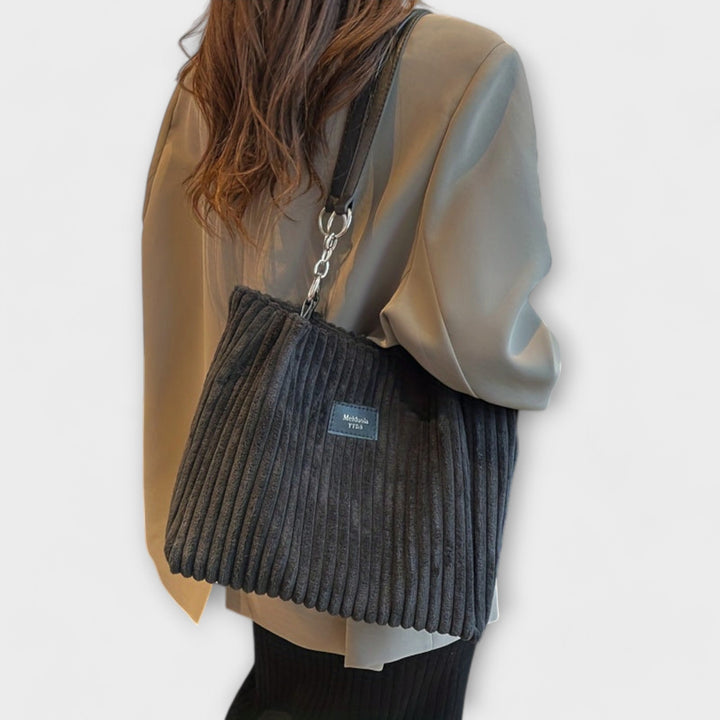 Versatile women's shoulder bag in modern style. Trendy everyday handbag, chic fashion accessory for women.