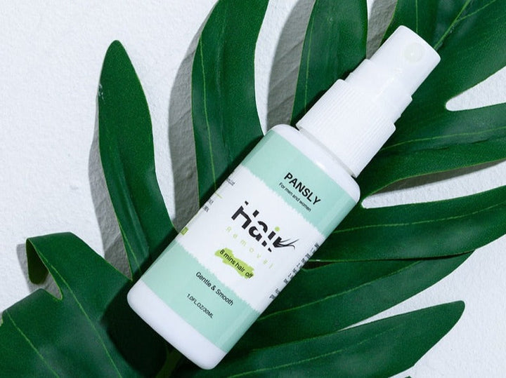 Unisex hair growth inhibitor spray for smooth skin, white bottle with green label, beauty product on a plain background.