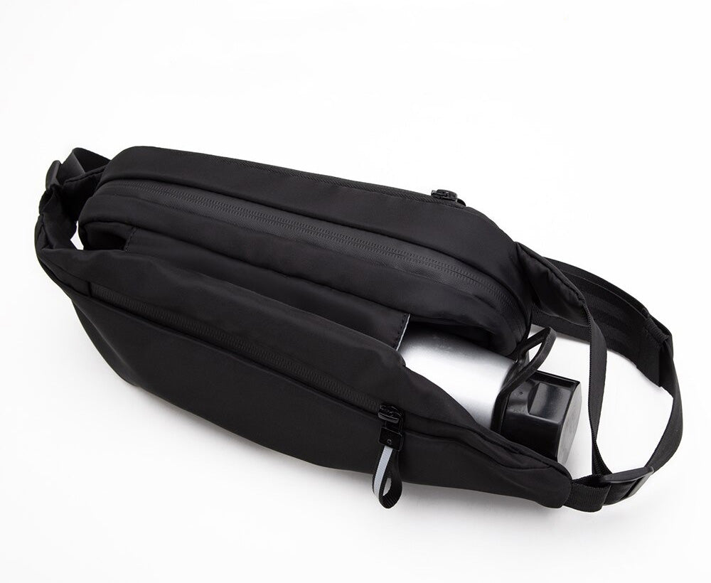 Close-up of the water-resistant fabric on a multi-pocket unisex fanny pack, showing zipper details.