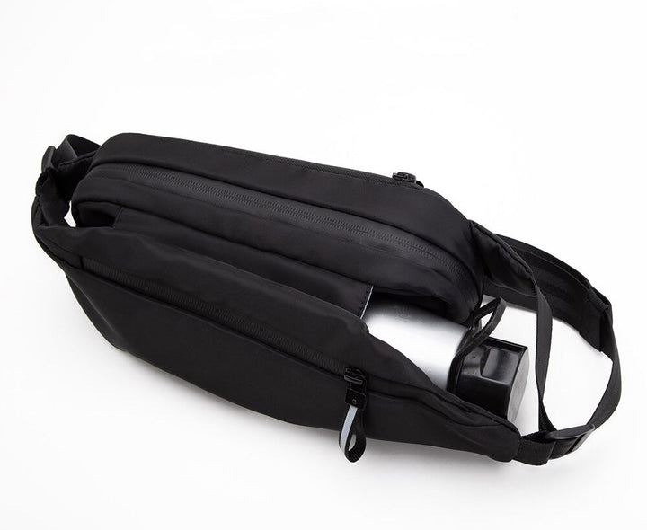 Close-up of the water-resistant fabric on a multi-pocket unisex fanny pack, showing zipper details.