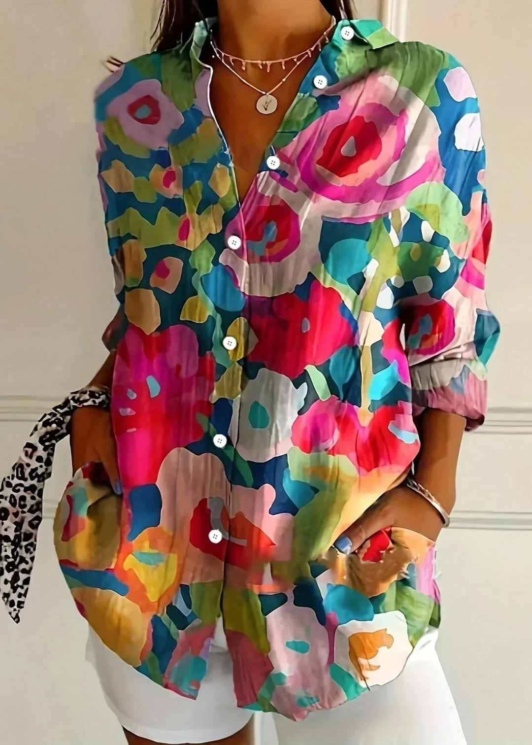 Close-up of the vibrant, colorful print detail on a women's long sleeve fashion blouse.