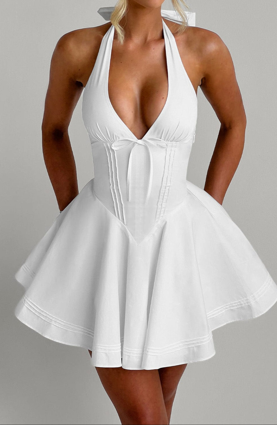 Trendy white halter mini party dress. A versatile sleeveless option for summer evening events.