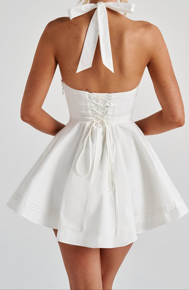 Elegant women's white halter neck mini dress with a flared skirt, perfect for any cocktail event.