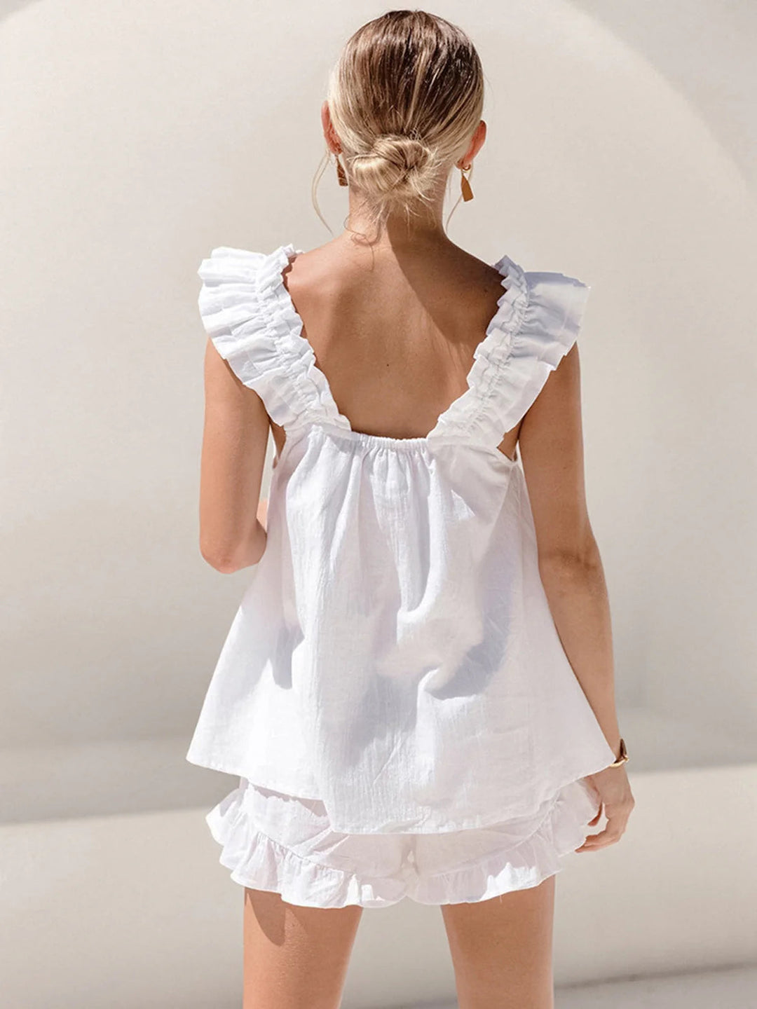 Chic white matching shorts set for women, with a sleeveless top and playful ruffled frill hem shorts.