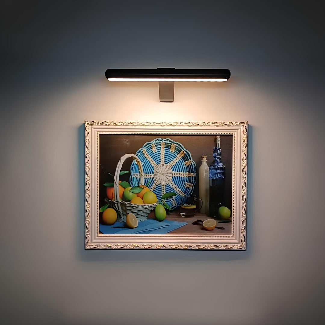 Dimmable wireless LED spotlight illuminating wall art. Rechargeable, perfect for modern home decor.