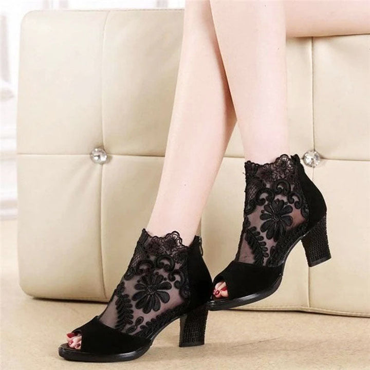 Stylish women's black peep toe heels with intricate floral mesh detailing & secure ankle strap for formal wear.