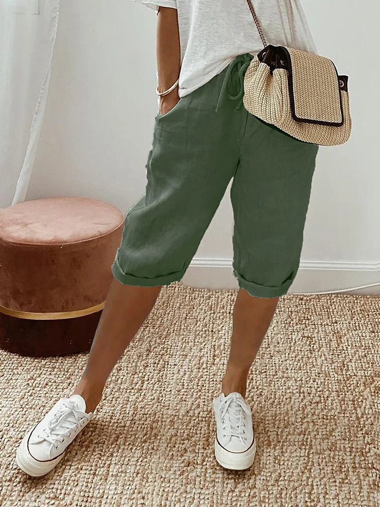 Woman wearing comfortable knee-length drawstring pants outdoors. Perfect for casual summer fashion & everyday flexibility.