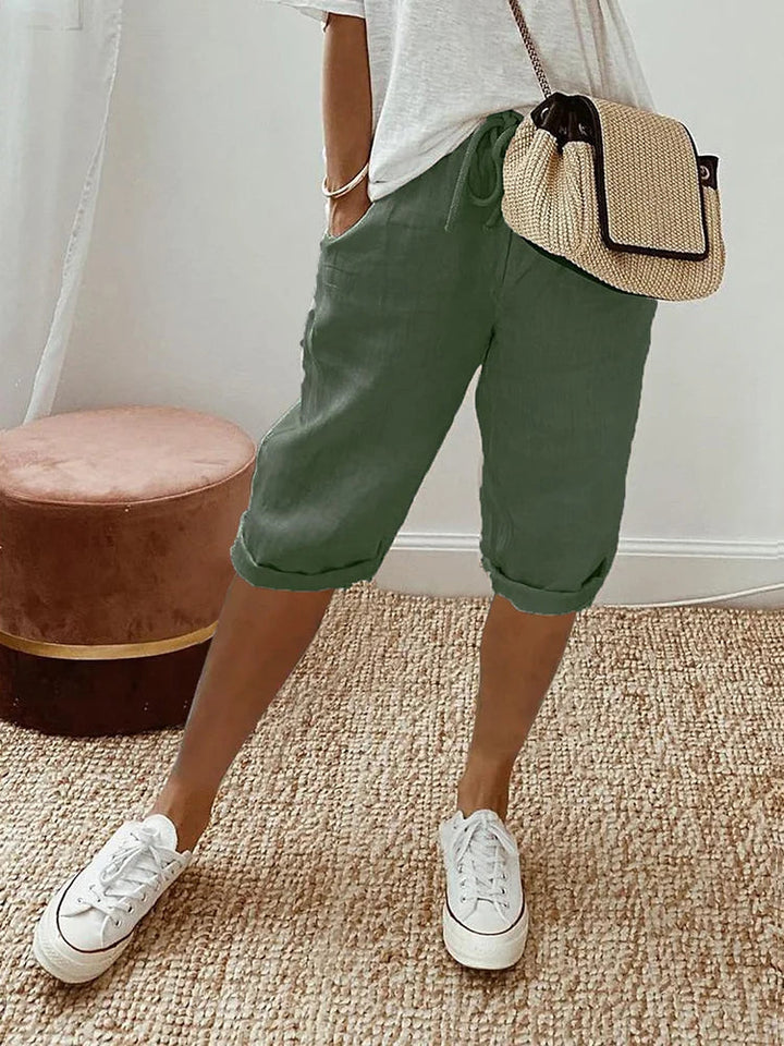 Woman wearing comfortable knee-length drawstring pants outdoors. Perfect for casual summer fashion & everyday flexibility.