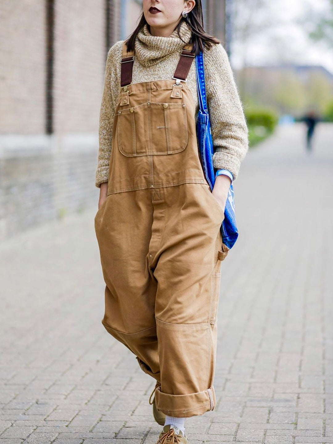 Fashionable woman wearing a sleeveless dungaree jumpsuit, styled casually for an effortless, chic look.