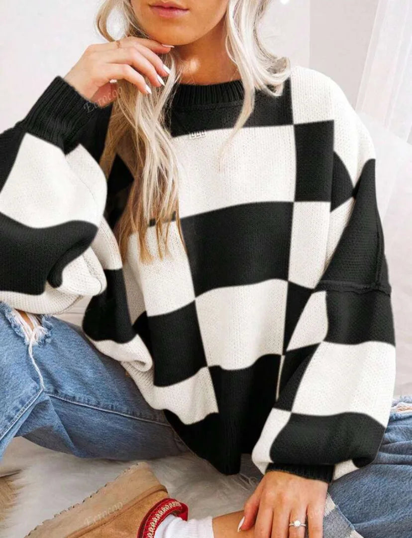Bold checkerboard pattern women's knitted sweater, oversized & cozy for stylish winter wear.