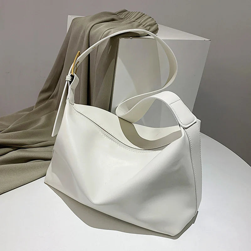 Slouchy faux leather tote bag with everyday items inside, a spacious women's hobo style for daily use.