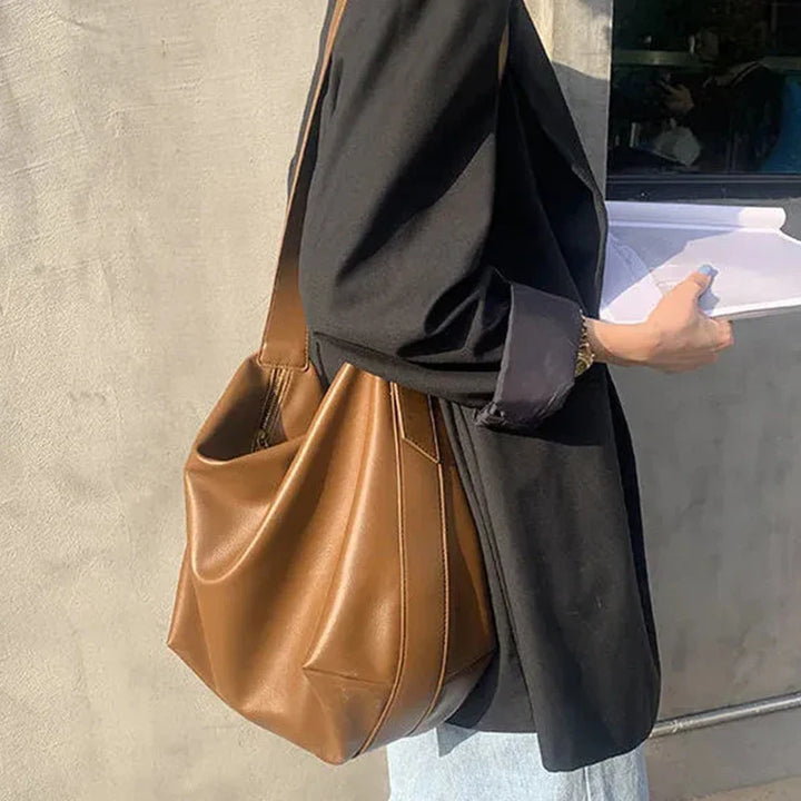 Close-up of soft faux leather texture on a stylish women's black slouchy tote shoulder bag.