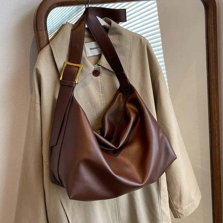Comfortable wide shoulder strap of a women's faux leather slouchy bag, designed for versatility.