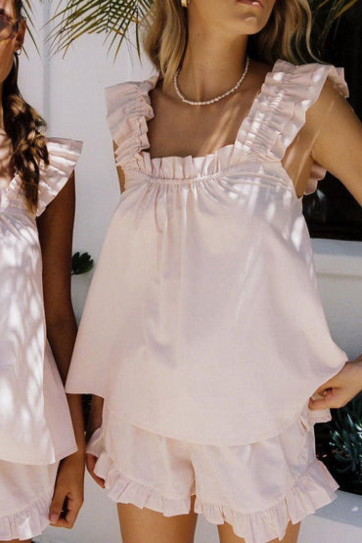 Stylish women's summer sleepwear set. Ruffled sleeveless top & shorts for cozy relaxation and warm weather comfort.