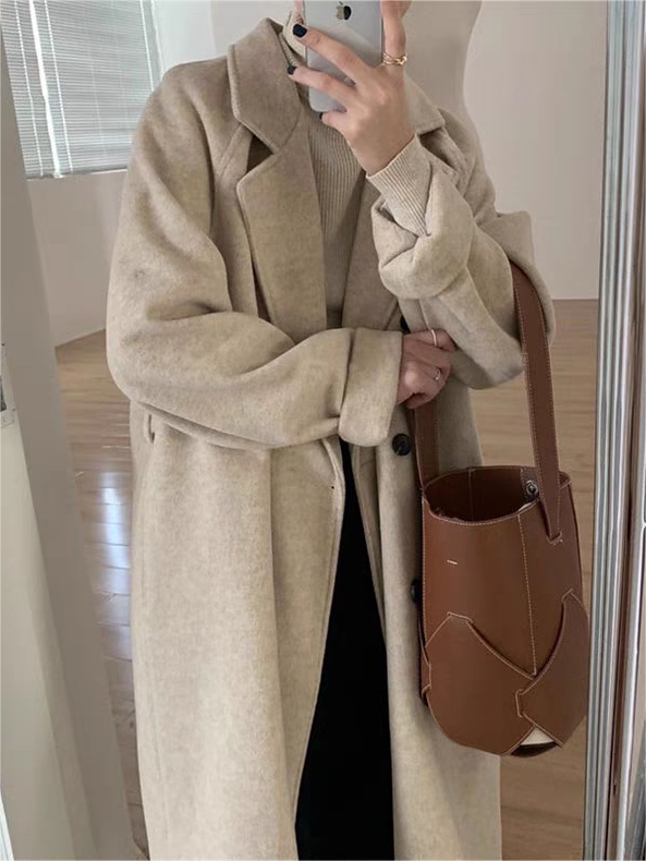 Elegant woman modeling a classic belted long winter coat, perfect for stylish cold weather fashion & warmth.