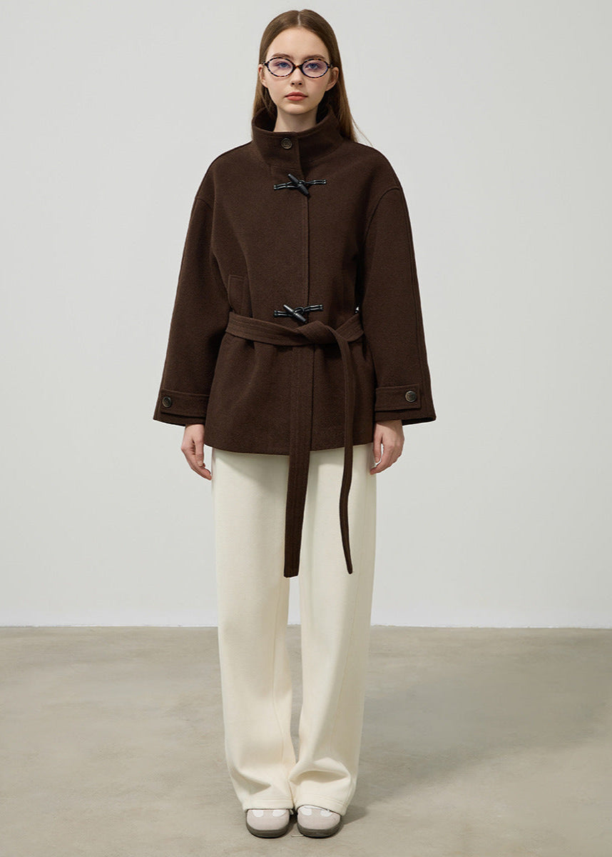 Close-up of women's classic toggle coat with detailed toggle closures, belt, and deep pockets.