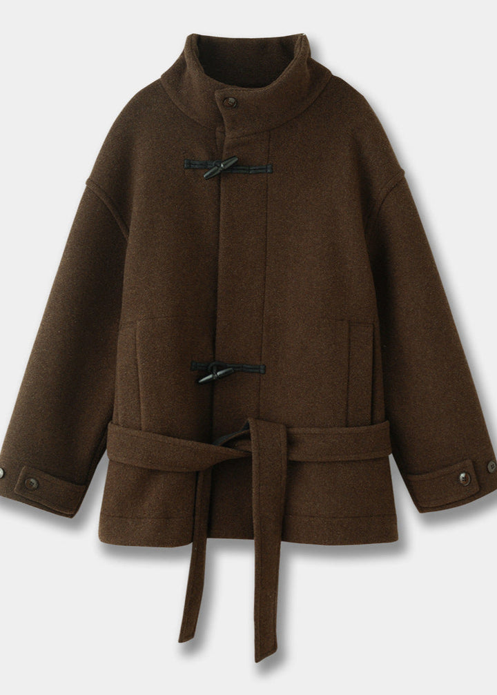 Full length shot of a women's elegant toggle coat with belted waist. A timeless winter fashion statement.