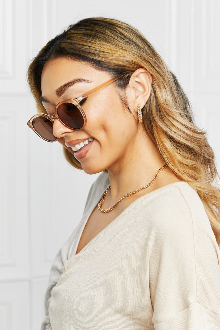 Elegant women's round UV400 sunglasses featuring a classic design and tinted protective lenses.
