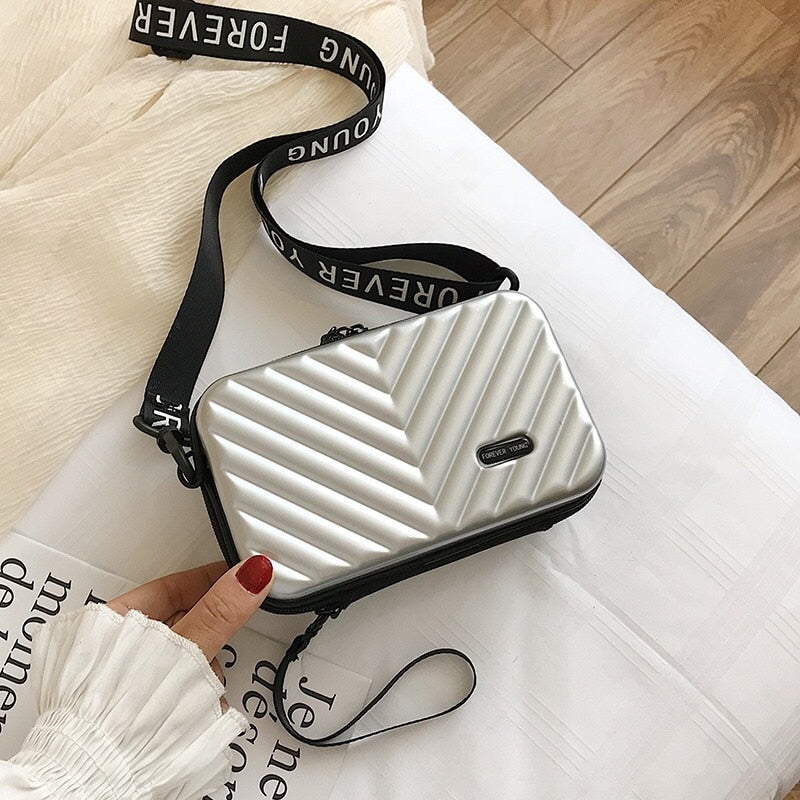 Sleek women's compact hard shell crossbody bag, durable vegan leather, ideal stylish travel accessory.
