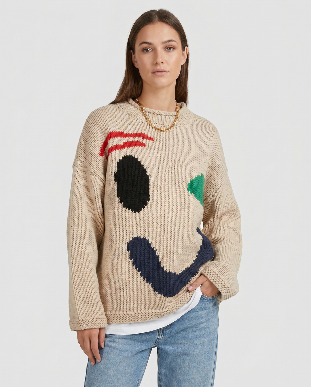 Model wearing a women's oversized smiley face sweater. Cozy, loose fit knit top for trendy fall fashion & casual comfort.