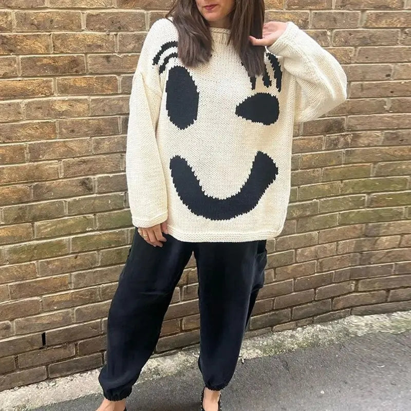 Women's trendy oversized smiley face sweater. Cozy knit top for ultimate fall fashion and essential winter warmth.