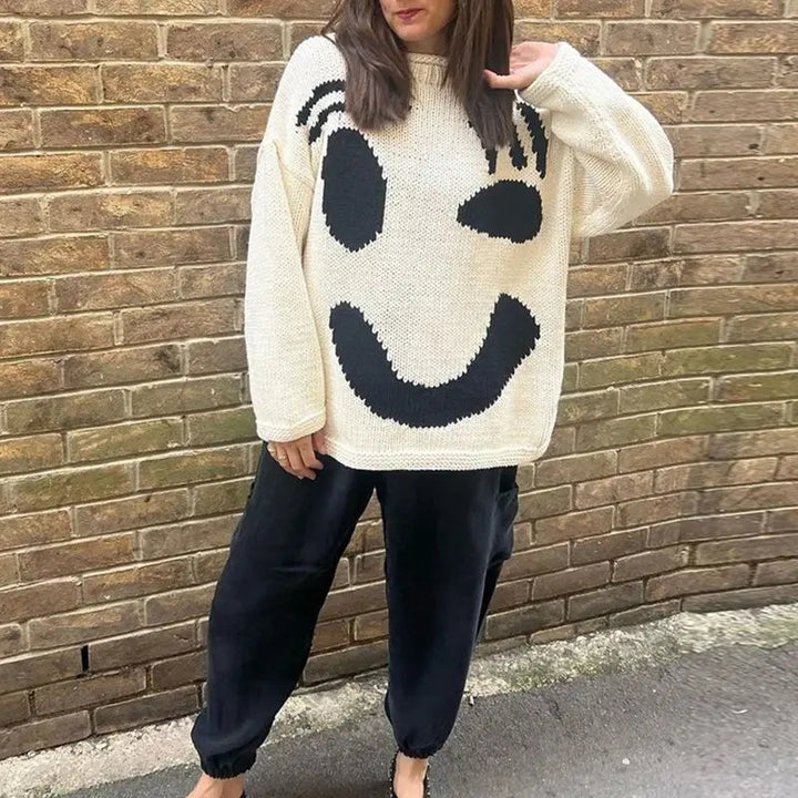 Women's trendy oversized smiley face sweater. Cozy knit top for ultimate fall fashion and essential winter warmth.