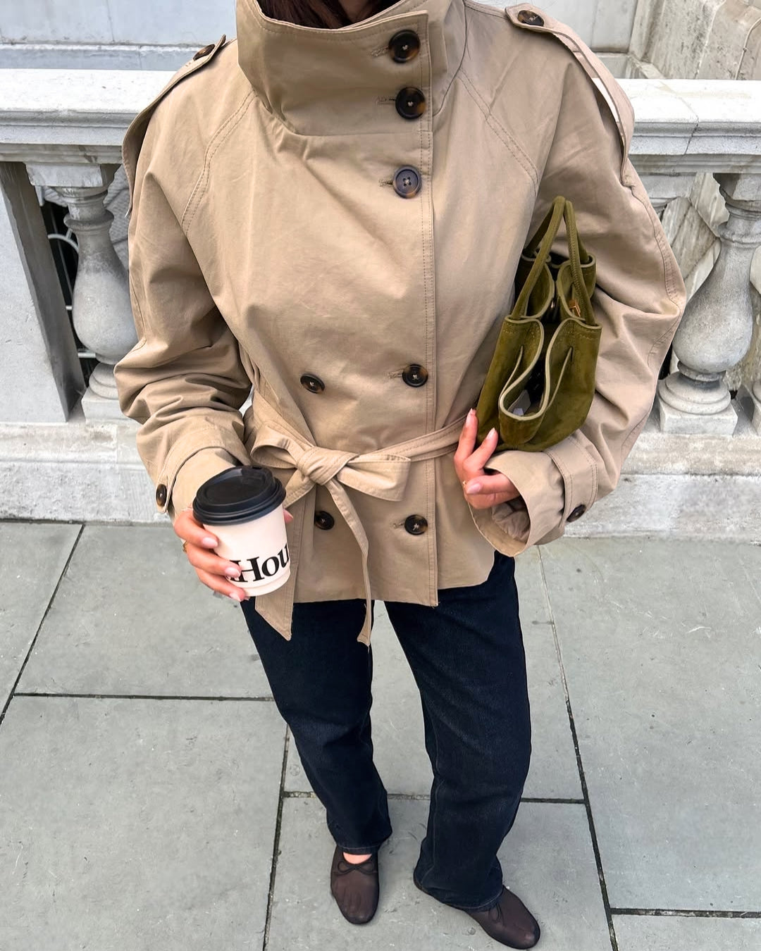 Versatile women's short trench coat, double-breasted and belted, ideal for elegant fall fashion.