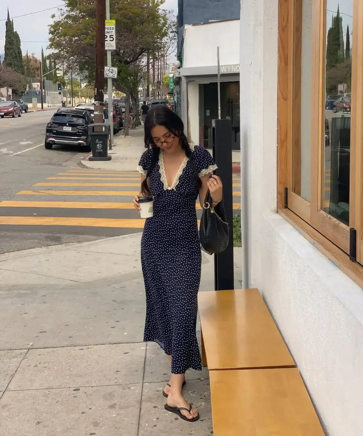Women's dark blue polka dot midi dress with flutter sleeves, perfect for casual summer elegance & everyday wear.
