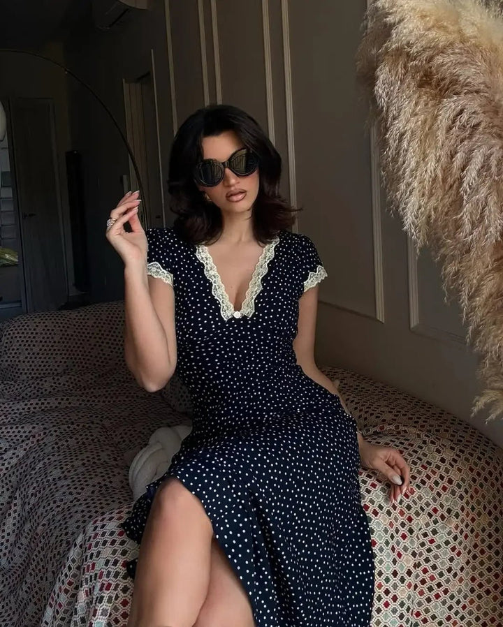 Effortless women's dark blue polka dot midi dress. Flutter sleeves, comfortable, ideal for casual summer events.
