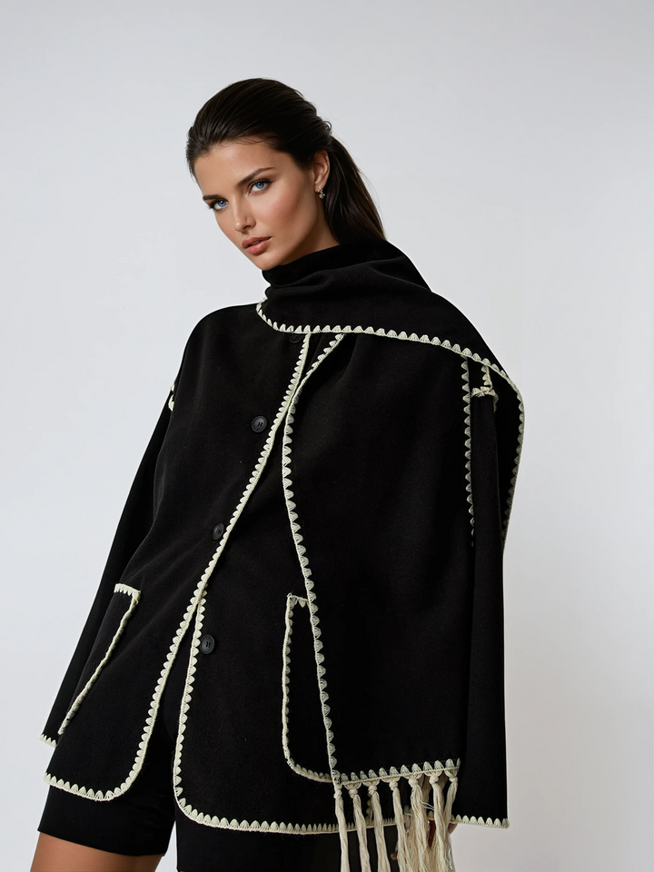Women's elegant black tailored jacket with a stylish fringe scarf, perfect for winter fashion outerwear.
