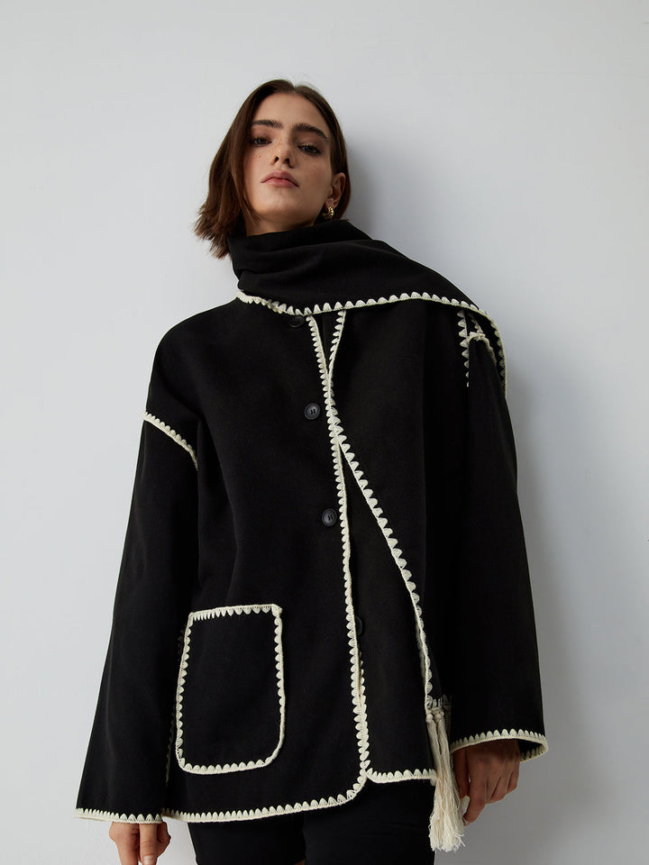 Stylish women's black tailored jacket with a cozy fringe scarf, ideal for elegant fashion and winter warmth.