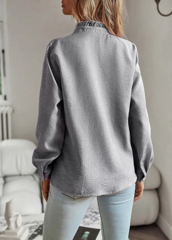 Close-up of women's elegant blouse fabric. Comfortable, timeless style top with sophisticated drape details.