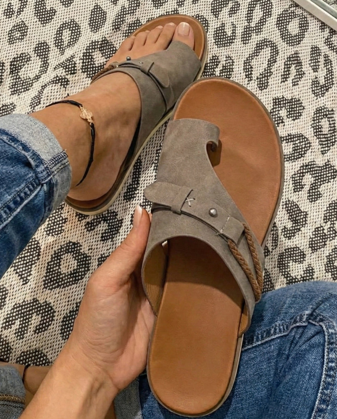Grey flat toe-loop sandals for women, offering warm weather comfort. Slip-on casual footwear for relaxed days.
