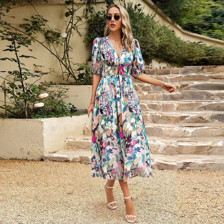 Chic women's flowing midi dress with a colorful floral pattern, versatile for summer casual or elegant events.
