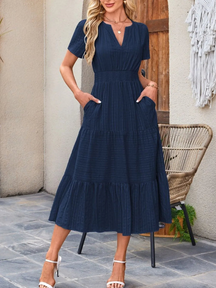 Summer-ready women's midi dress with flowy fabric, short sleeves, & practical pockets.