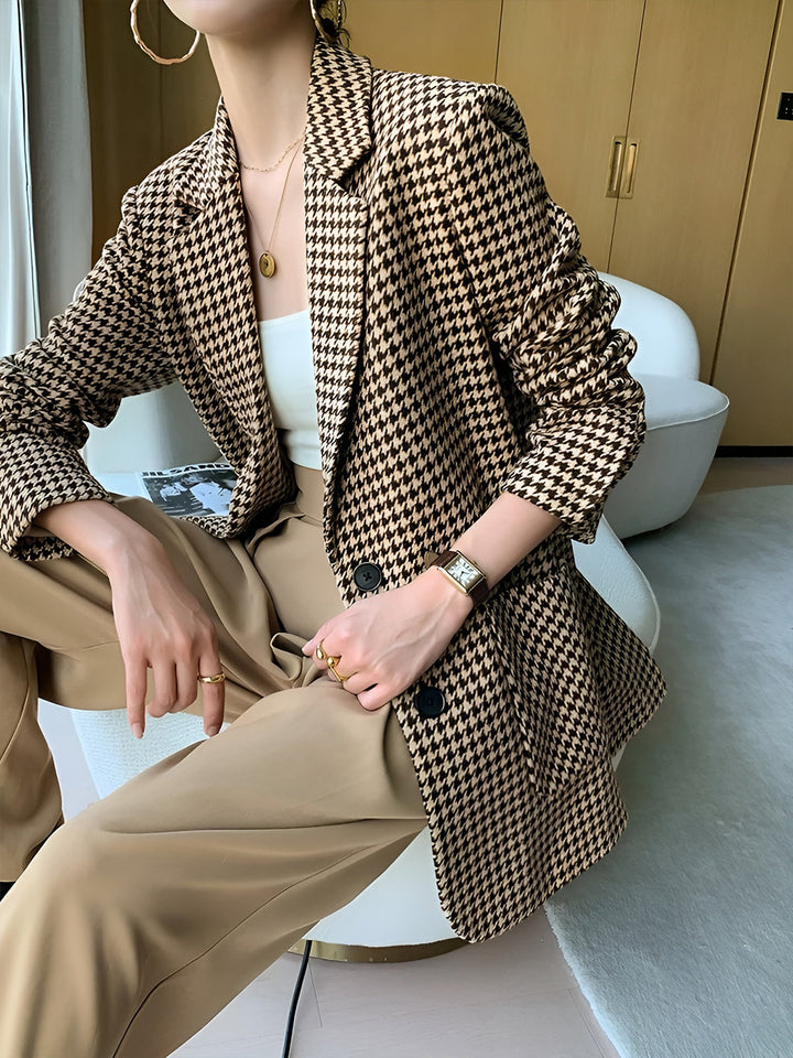 Tailored women's houndstooth blazer, belted at the waist with a modern split-hem. Professional & stylish.
