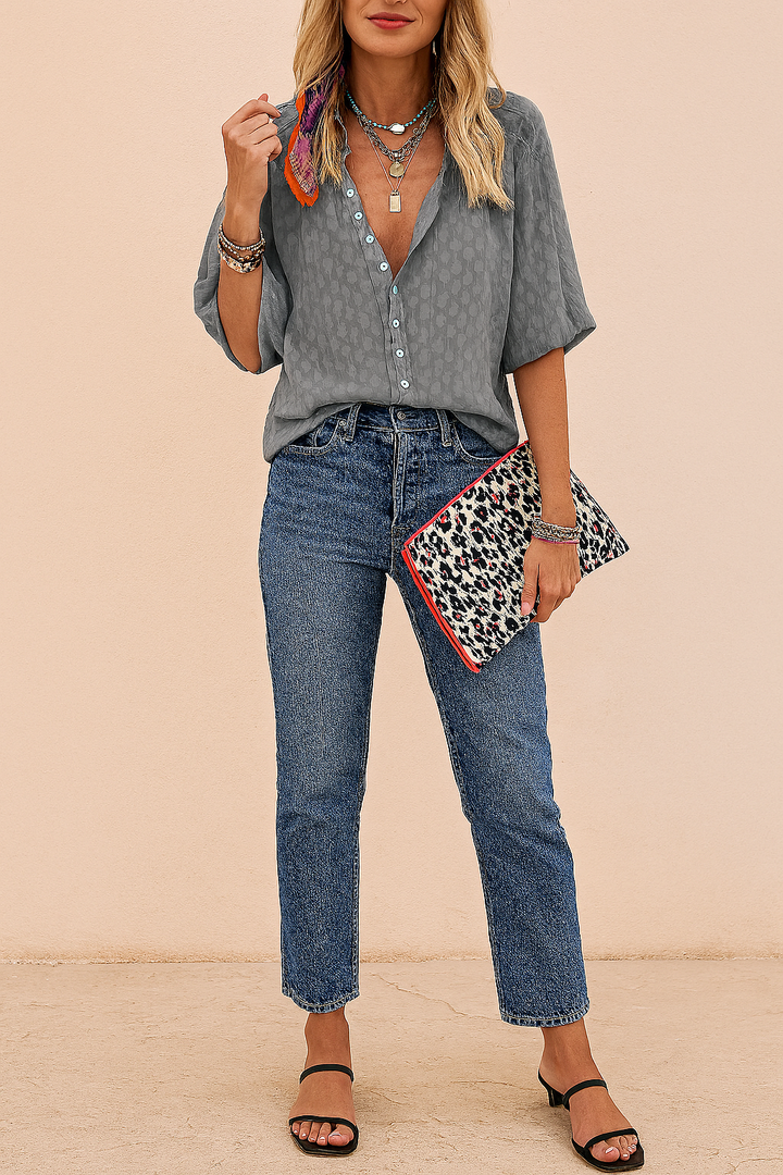 Model wearing a chic women's oversized summer blouse. Loose-fit, lightweight short-sleeve top for casual fashion.
