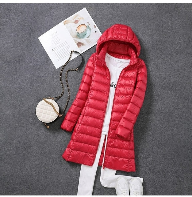 Stylish women's long puffer jacket. Keep warm with this fashionable winter coat featuring a versatile detachable hood.