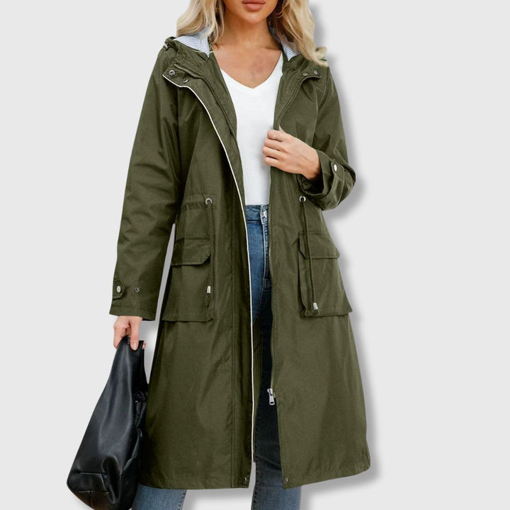 Close-up of women's zip-up long rain jacket, highlighting the adjustable hood and drawstring waist detail.
