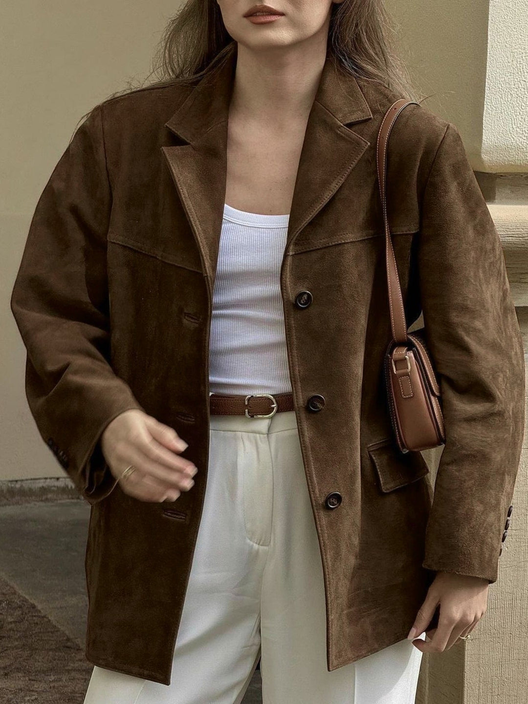 Women's luxurious brown suede oversized button-front jacket with notched lapel. Versatile modern layering piece.