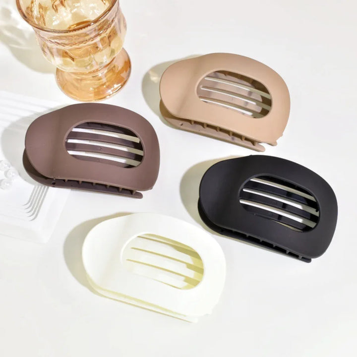 Matte finish oval flat hair clip for elegant women's bun hairstyles.