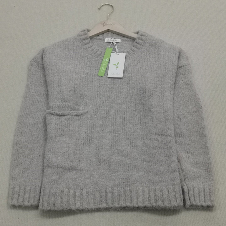 Close-up of the knitted texture on a women's oversized jumper, emphasizing cozy autumn comfort.