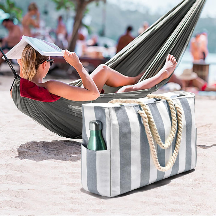 Women's oversized waterproof beach bag, sandproof, standing upright on the sand.
