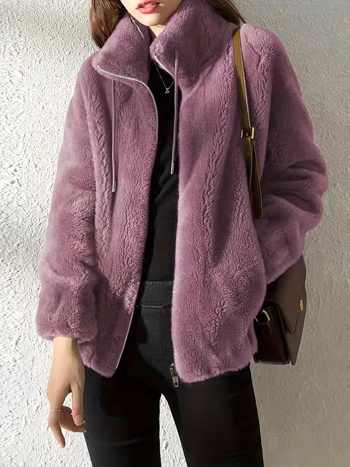 Fashionable women's long-sleeve plush teddy coat. Features a central zipper & adjustable drawstring waist.