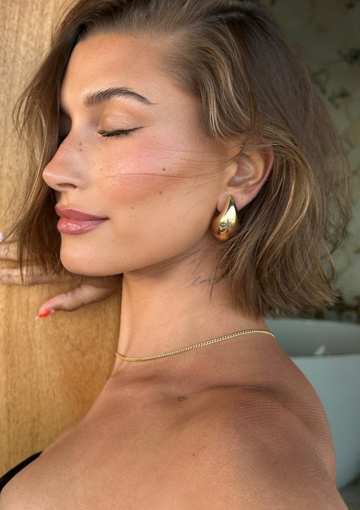 Women's polished teardrop dangle earrings. Minimalist fashion jewelry in gold or silver.