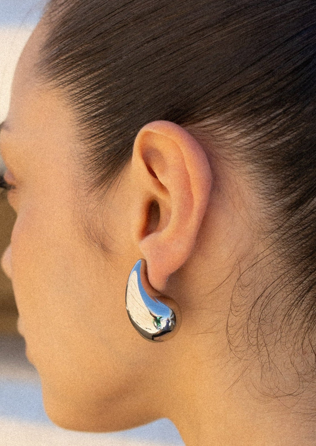 Shiny gold teardrop dangle earrings for women, a timeless piece of polished jewelry.