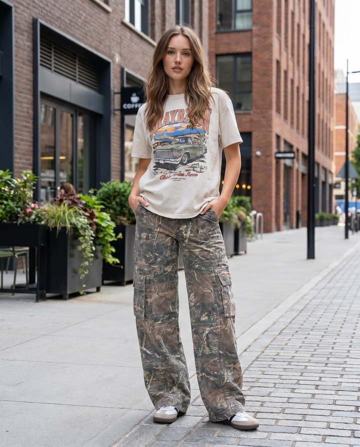 Model wearing women's relaxed camo cargo pants, wide-leg utility bottoms for a streetwear look.
