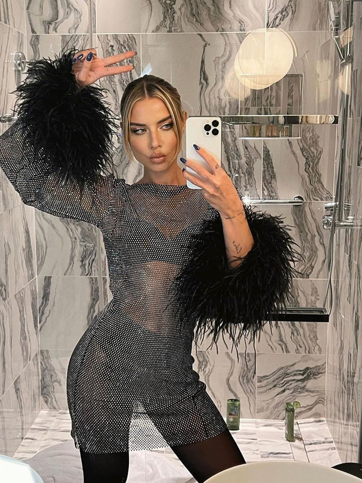 Model wearing a glamorous women's metallic feather cocktail dress, shimmering for a statement evening look.
