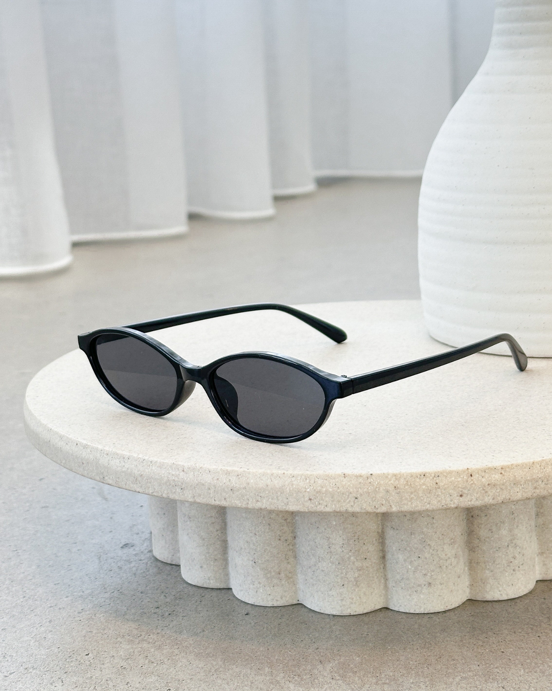 Classic women's oval sunglasses with a sleek frame, ideal for a minimalist retro accessory.